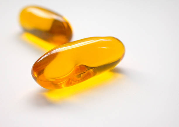 желтый таблетки витамина гели - vitamin pill picking up pill capsule стоковые фото и изображения