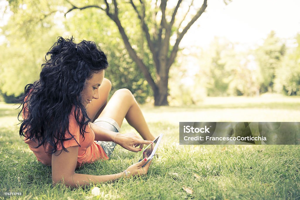 Mulher usando um tablet digital no parque - Foto de stock de Adulto royalty-free