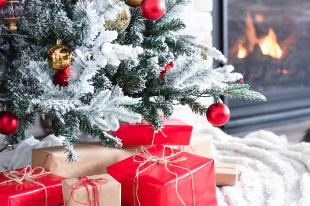 istock Cute grey cat lying under Christmas tree with wrapped presents 1767743900