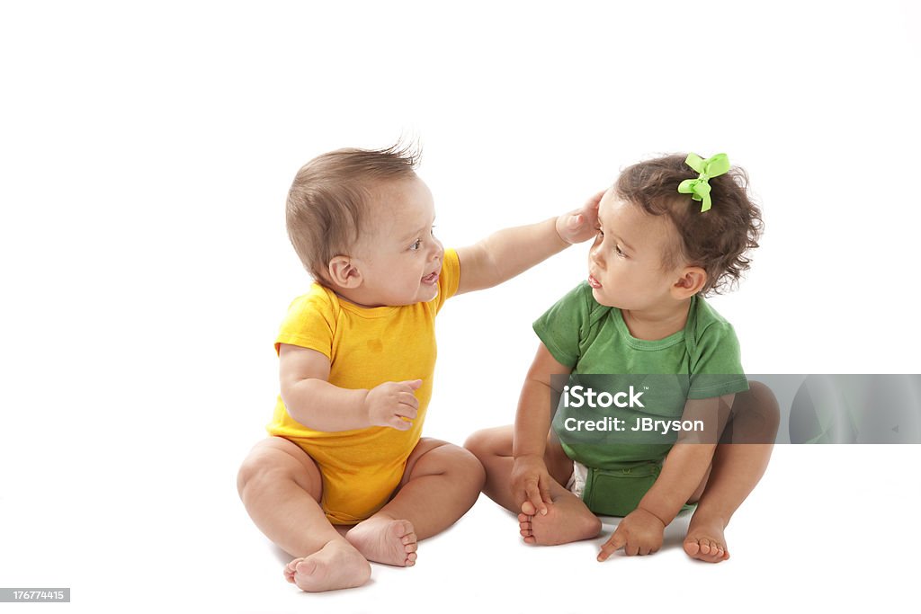 Multiracial babies playing upon white background One year old girl of mixed ethnicity is black and caucasian, boy is hispanic. Babies Only Stock Photo