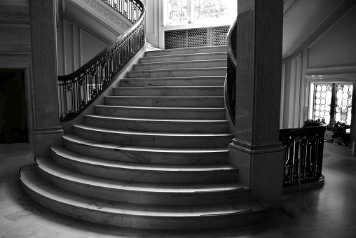 Staircase in decayed building. Focus on wall in foreground with flaking paint.