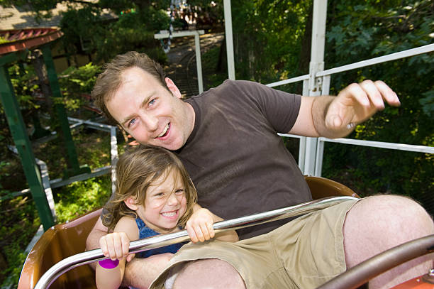 istock Father and daughter smiling, riding a roller coaster  176775280