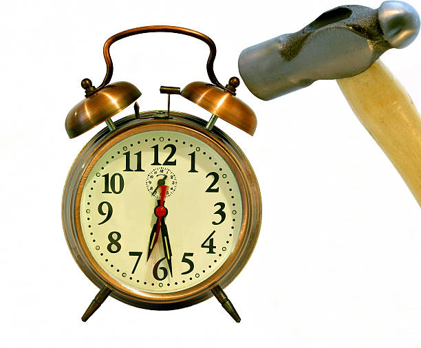 Monday morning blues. An alarm clock being smashed by a hammer on Monday morning. Who wants to go to work. smash alarm clock stock pictures, royalty-free photos & images