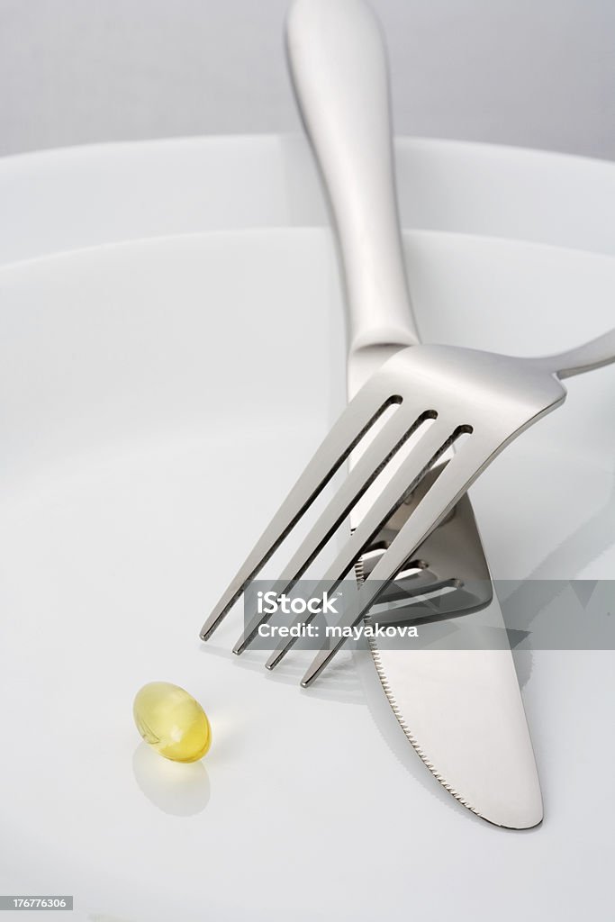 Capsula sul piatto con forchetta e Coltello - Foto stock royalty-free di Alimentazione sana