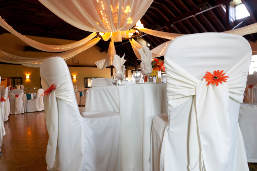 Wedding venue with covered chairs and ceiling decoration