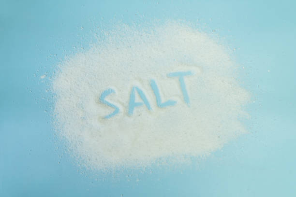 istock the word salt is written with salt on a blue table. Salt grain top view on blue background. 1767768485