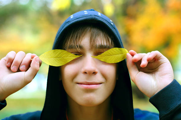 The cheerful teenager in autumn park