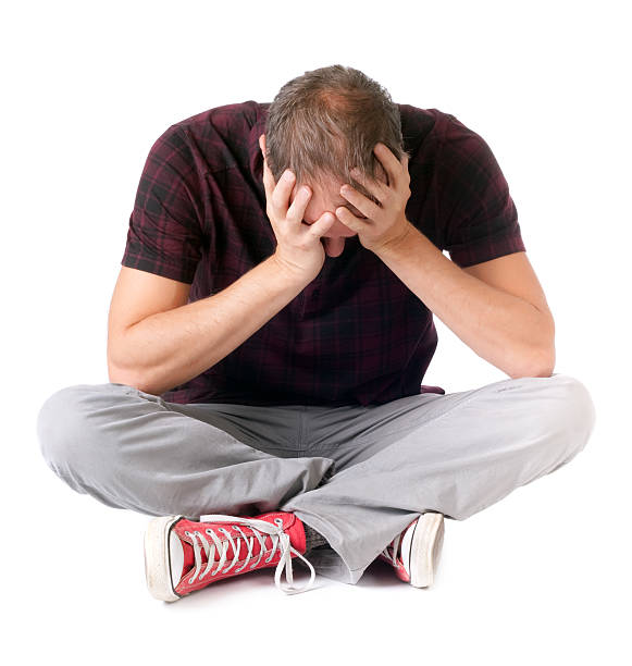 istock Man sitting with his legs crossed and holding his head 176777896