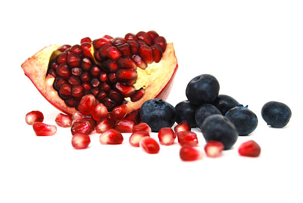 Superfruits on white background "Blueberries and pomegranate seeds, sometimes called arils, on a white background.Pomegranates and blueberries are considered superfruits, and are high in key antioxidants, as well as being high in vitamin C and darned tasty, too." superfruit stock pictures, royalty-free photos & images