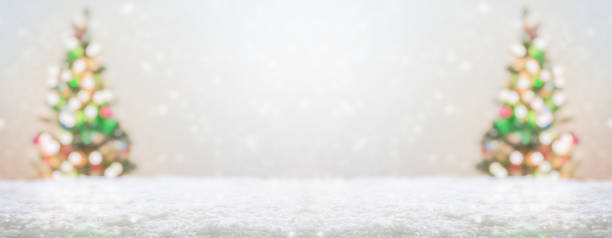 Empty white snow with blur Christmas tree with bokeh light background