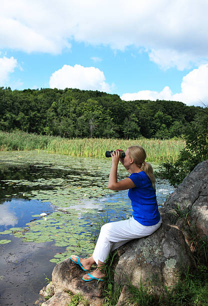 Woman looking through binoculars stock photo