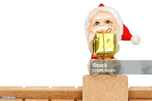 Foto de Papai Noel No Telhado Segurando Um Presente e mais fotos de stock de Amarelo - Amarelo, Bola de Árvore de Natal, Boneca