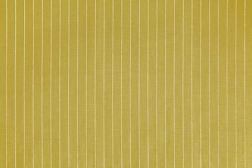Striped yellow white fabric texture background wtih copy space. Shirt fabric, tablecloth textile, garment cloth, upholstery with classic pattern with lines. Backdrop, wallpaper, background.