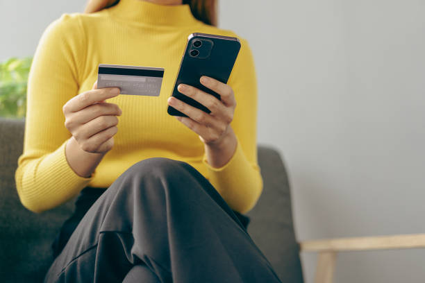 Close up of woman's hands holding credit card and smartphone and laptop Young woman pays online using bank, enters order information in internet shop, online name concept primer plano de las manos de la mujer sosteniendo la tarjeta de crédito y el teléfono inteligente y la computadora portátil la mujer joven paga en línea usando el banco, ingresa la información del pedido en la tienda de internet, concepto de nombre en