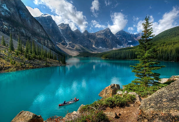 Moraine Lake "Boaters on Moraine Lake, Banff National Park, Alberta, Canada." moraine lake stock pictures, royalty-free photos & images