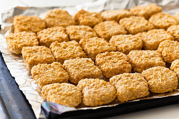 Chicken nuggets arranged on oven tray