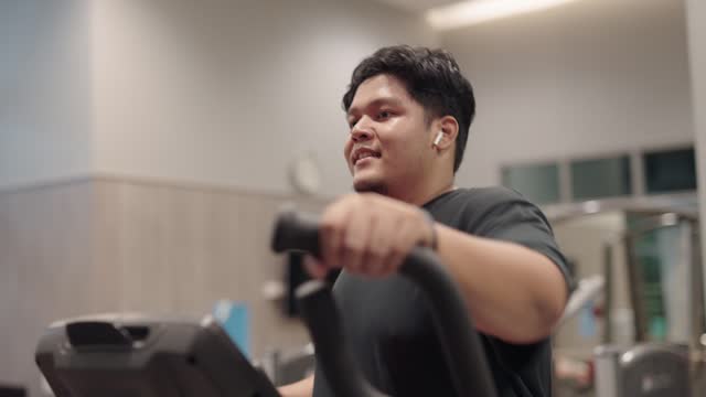 Overweight man training on an elliptical trainer