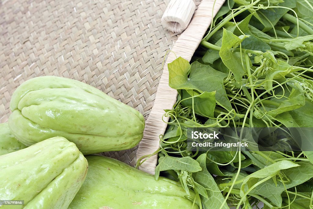 Fresh Chayote and vines Fresh Chayote with plant vines in wicker basket. Basket Stock Photo