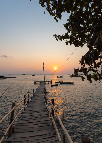 Sunset on the beach with a wooden bridge at Hon Nghe, Kien Giang province