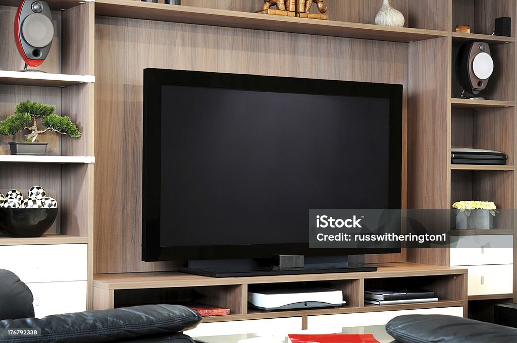 TV and lounge A large flat screen TV in shelving unit in lounge Television Set Stock Photo