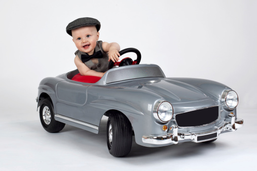 little boy in a toy car