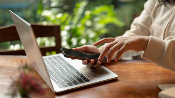 istock Side view image of a woman in casual clothes using her smartphone while working remotely at a cafe. 1767945715