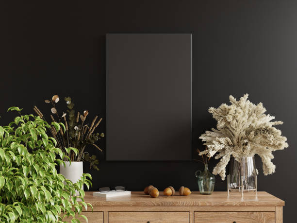 istock Mockup black poster frame on cabinet in living room interior on empty dark wall background 1767953855