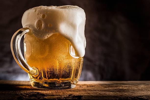 Frosty foaming mug full of beer stock photo