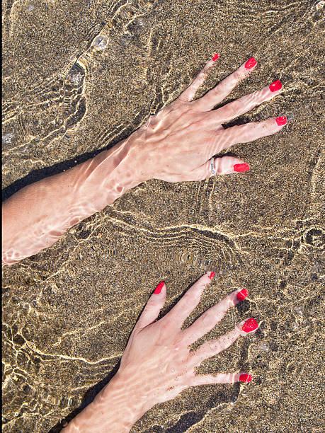 woman hands on  water foreshore,  black sand stock photo