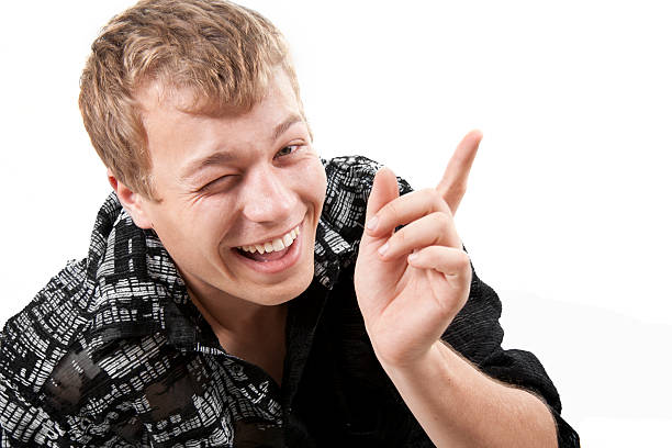 istock young man miles and points a finger upwards 176796323