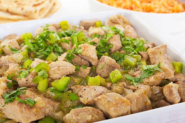 Chili Verde Green Mexican Food "Chile verde, pork stewed with tomatilloes, jalapenos, onion, garlic, garnished with green capsicum and coriander. Served with Spanish rice and home made wheat tortillas. Yummy!" tomatillo photos stock pictures, royalty-free photos & images
