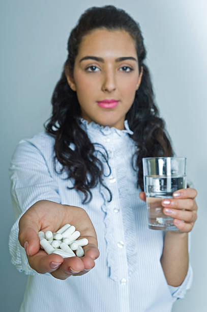 женщина принимать таблетки - sozial стоковые фото и изображения