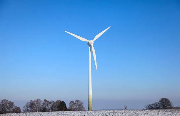 a wind turbine against blue clean sky in winter