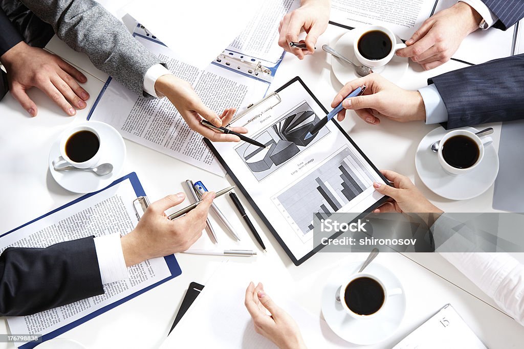 Hands pointing to graphs during explanation Image of hands of working businesspeople at meeting Business Stock Photo