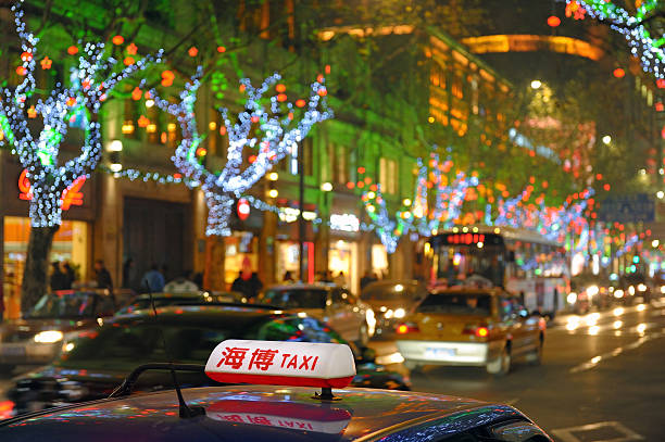 Shanghai street by night with taxi driving down the road stock photo