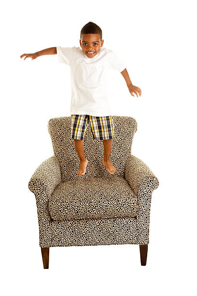 laughing Young black child trying to get out of chair
