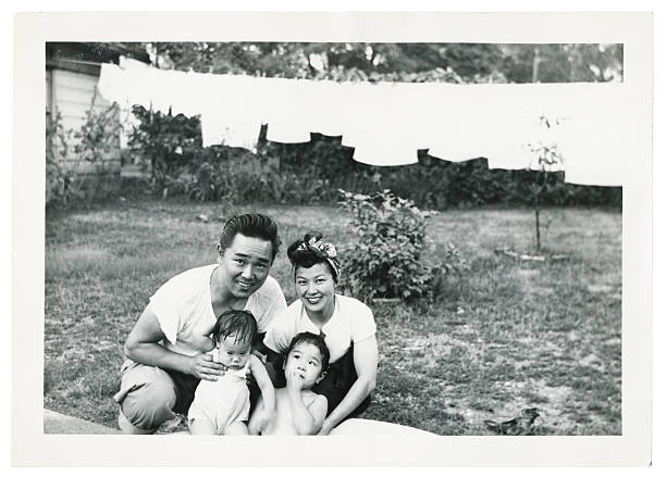 Happy Young Asian Family Outside "young asian family, scanned photograph, 1950's, some dust and scratches left in to show age" human made structure photos stock pictures, royalty-free photos & images