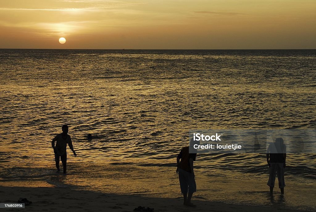 Crianças brincando na praia no pôr-do-sol - Foto de stock de Aldeia royalty-free