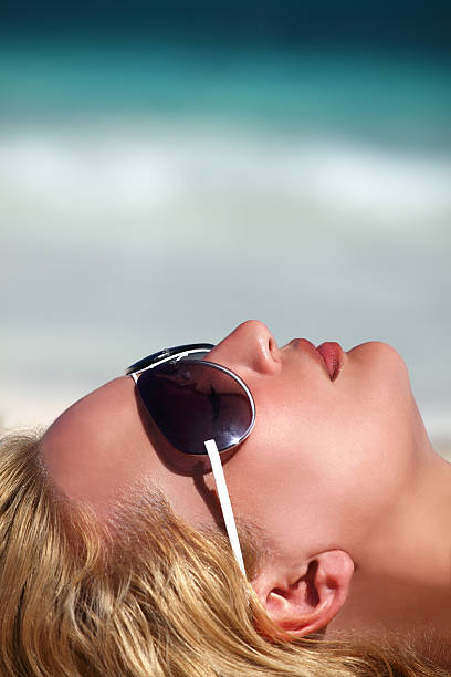 beautiful young woman takes  sun at the beach stock photo