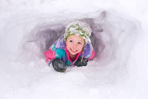 istock Young girl crawling through snow tunnel 176804672