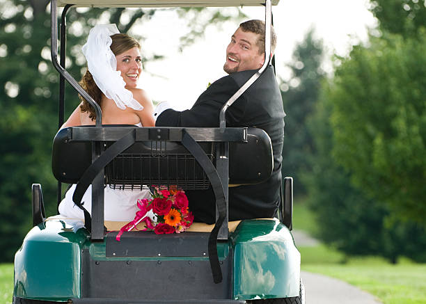 alegre noiva e o noivo em um carrinho de golfe - golf course golf people sitting - fotografias e filmes do acervo