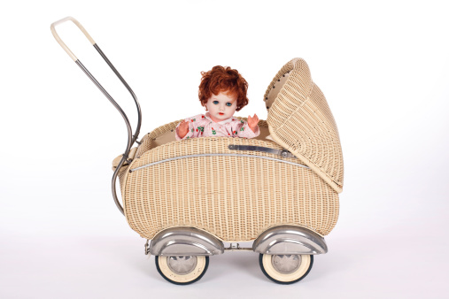 old doll's carriage made of basket with doll