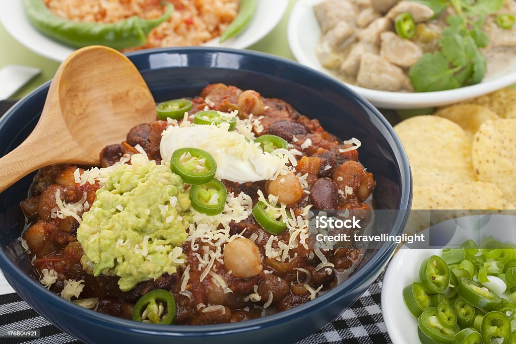 Mexican Food Selection "A selection of home made Mexican food, chilli beans with sour cream, avocado and cheese, Spanish rice with tomato, corn chips and chillies. Shallow DOF." Avocado Stock Photo