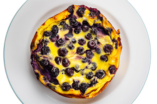 Top view of freshly baked homemade yogurt blueberry cake in white ceramic dish isolated on white background with clipping path.