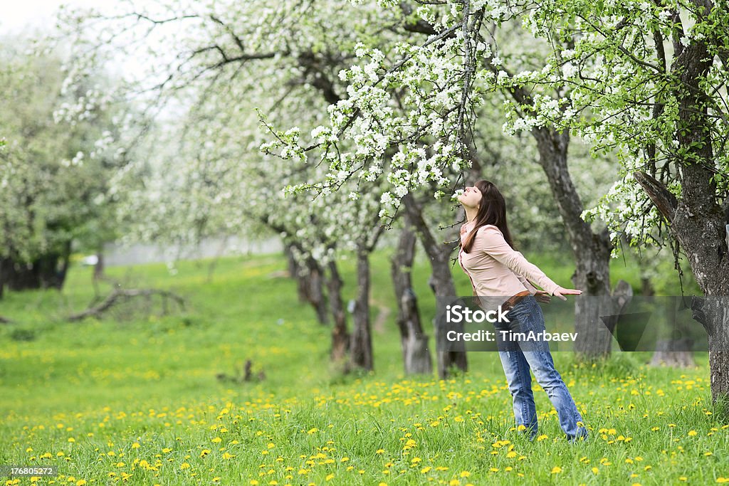 Woman smelling flowers Young woman smelling apple flowers in the garden Adult Stock Photo