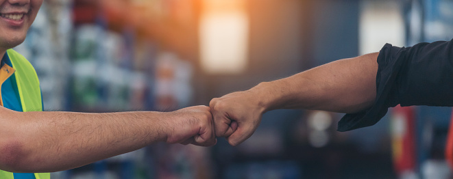 Banner Asian Teamwork Warehouse worker fist bump together. Engineer man, women hands partnership. Coworker colleague logistics Warehouse teams handshake. Team person fist bump partner with copy space