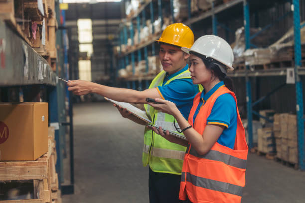 istock Asian men women worker use bar code scaner scan goods shelf writing checklist on clipboard. Warehouse management team check stock inventory. Teamwork logistics staff counting products store inventory 1768062663