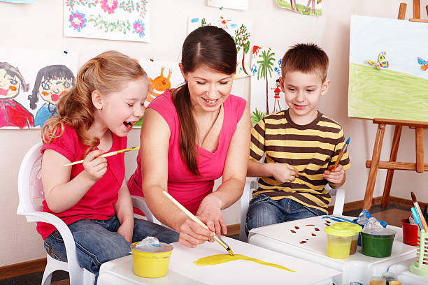 istock Children with teacher draw paints in play room. 176806656