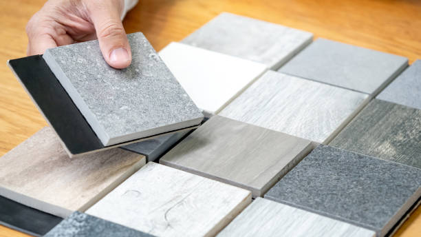 istock Architect hand choosing sample of stone material or tile texture collection on the table in studio. Designer working for interior architecture and furniture design project. 1768084582