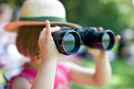 young girl looking through binoculars